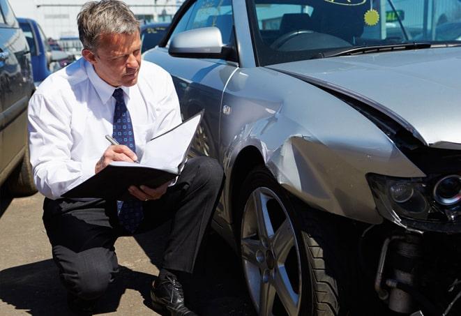 grey car driving on road with insurance agency billboard in background